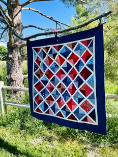 patriotic quilt hanging in tree, left angle view